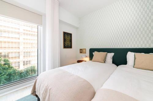 里斯本的住宿－Liberdade Terrace Apartment，一间卧室设有两张床和窗户。