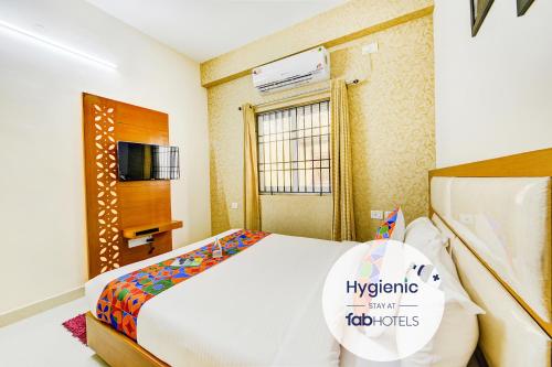 a bedroom with a large bed and a tv at FabHotel Sky Bay Residency - Near Kodambakkam Railway Station in Chennai