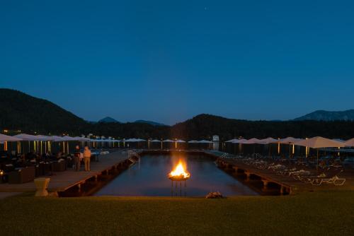 a pool with a fire in the water at night at Promenaden-Strandhotel Marolt in Sankt Kanzian