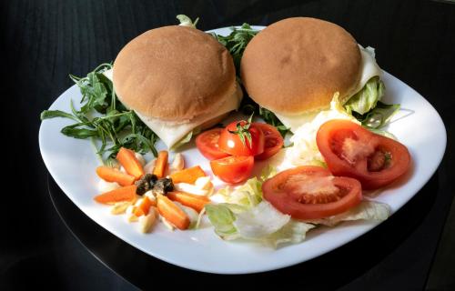two sandwiches on a plate with vegetables and carrots at Growel Exclusive Suites San Pietro in Rome