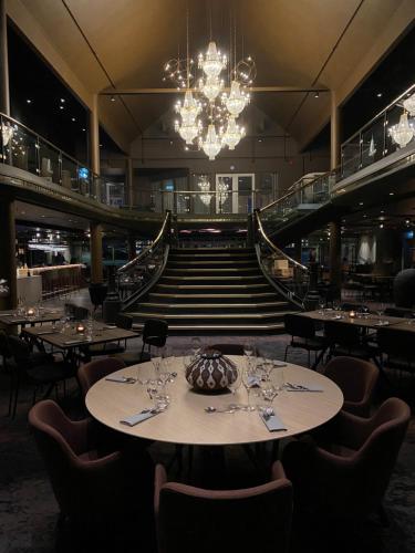 a dining room with a table and a chandelier at Rognan Hotel in Rognan