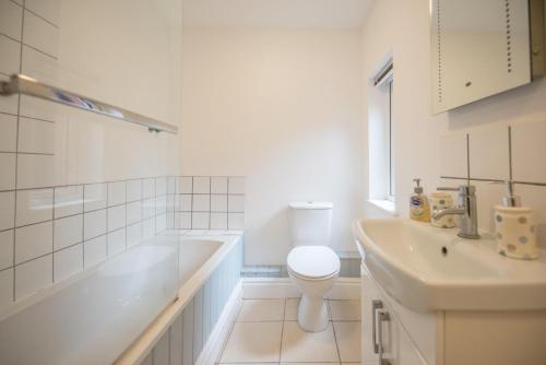 biała łazienka z toaletą i umywalką w obiekcie 2 Abbey Mews, Leiston w mieście Leiston