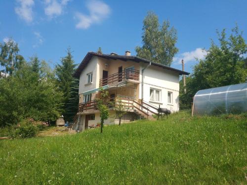 a house on top of a hill with a field at Guest House Bovada / Къща за гости Бовада 