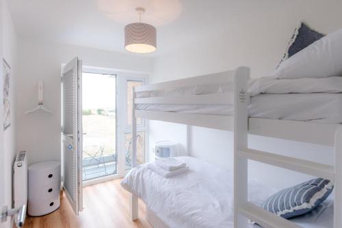 a bedroom with two bunk beds and a window at 4 Sea View Walk, Pakefield in Pakefield