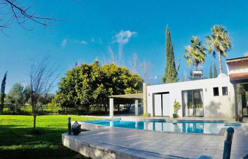 a villa with a swimming pool in front of a house at The Stone Villa in Pissouri