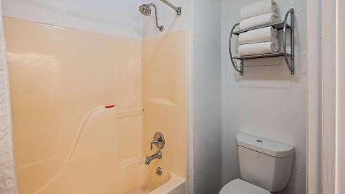 ein Bad mit einem WC und einer Dusche mit Handtüchern in der Unterkunft SureStay Plus Hotel By Best Western San Antonio North 281 N in San Antonio