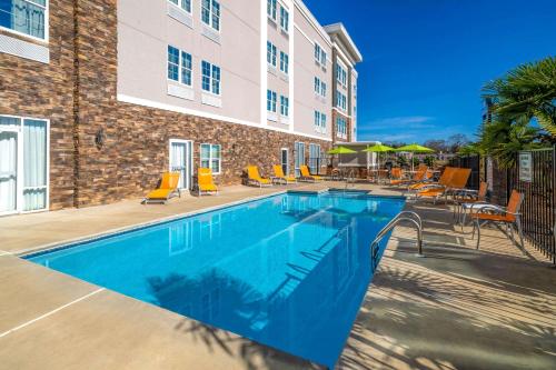 a swimming pool in front of a building with chairs at La Quinta by Wyndham Forsyth in Forsyth