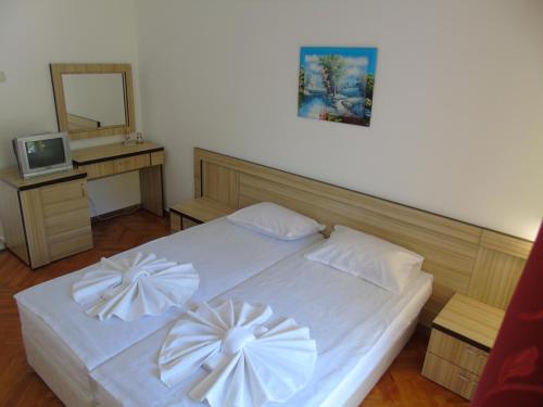 a bedroom with a white bed with white bows at Jupiter Hotel in Sunny Beach