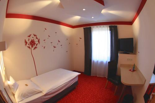 a hotel room with a bed and a desk and a window at Hotel-Restaurant Zum Goldenen Löwen in Kelkheim