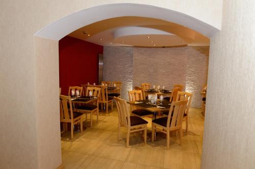 a dining room with wooden tables and chairs at Four Saints Brig Y Don Hotel in Llandudno