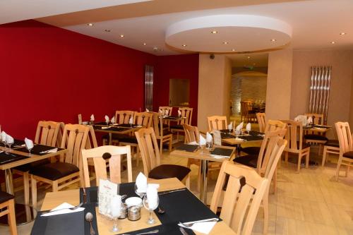 a restaurant with tables and chairs in a room at Four Saints Brig Y Don Hotel in Llandudno