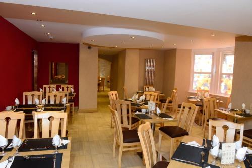 a restaurant with tables and chairs in a room at Four Saints Brig Y Don Hotel in Llandudno