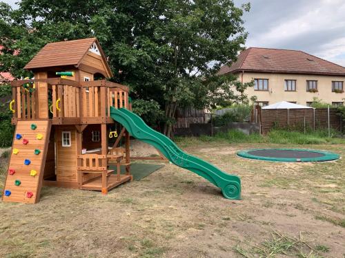 a wooden playground with a slide and a play structure at Penzion Black Hole in Provodín