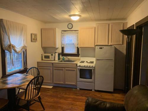 a kitchen with white appliances and a table and a table and chairs at Echo Valley Cottages in Coolbaugh
