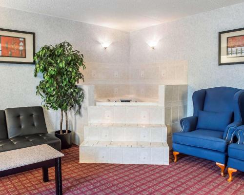 a living room with two blue chairs and a tub at Quality Inn & Suites North Gibsonia in Gibsonia