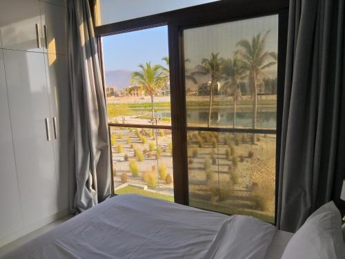 um quarto com uma janela com vista para um resort em NEW Exclusive Family Suite With Breathtaking View em Salalah