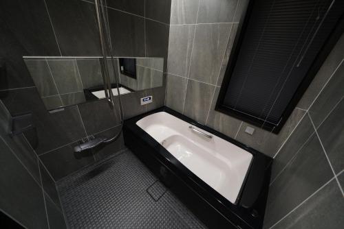 een badkamer met een wastafel en een spiegel bij Tombi Lodge in Iiyama