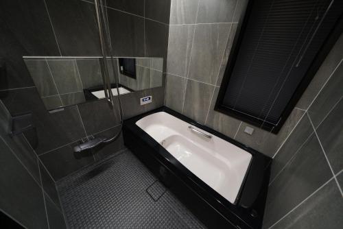 a bathroom with a sink and a mirror at Tombi Lodge in Iiyama