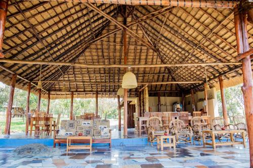 a large wooden pavilion with tables and chairs at Mama Washindi Lodge in Pakwach East