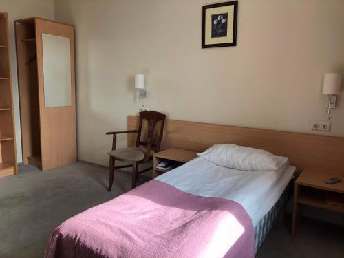 a hotel room with a bed and a chair at TOSS Hotel in Rīga