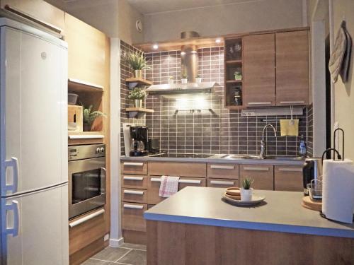 a kitchen with a refrigerator and a counter top at 2ndhomes Tampere "Rautatieasema" Apartment - Heartful New Apt with Balcony in the City Center in Tampere