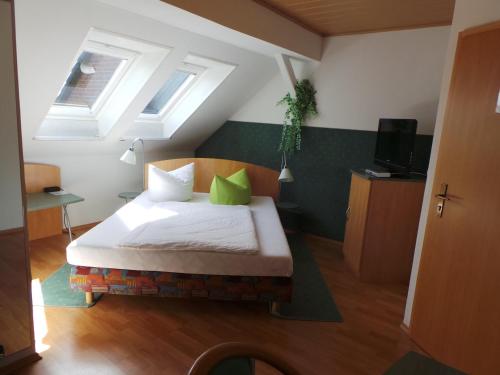 Un dormitorio con una cama con almohadas verdes y una ventana en Hotel & Restaurant Hildebrandt, en Breitenrode