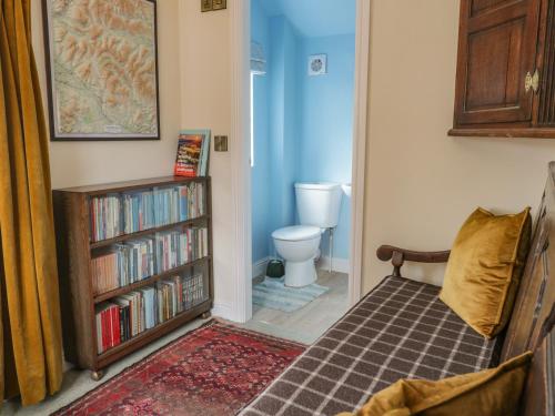 ein Schlafzimmer mit einem Bücherregal mit Büchern und einem WC in der Unterkunft Bridgend Cottage in Skipton