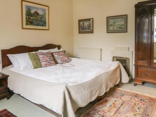 a bedroom with a bed and a fireplace at Bridgend Cottage in Skipton