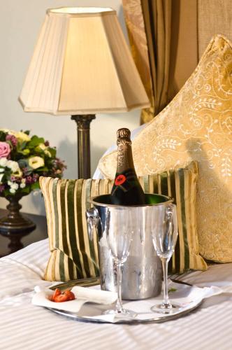 a bottle of wine in a bucket on a bed at Macdonald Drumossie Hotel Inverness in Inverness