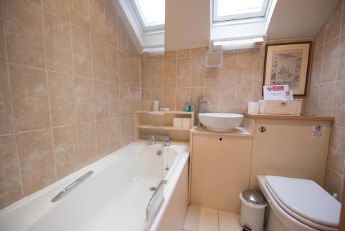 een badkamer met een bad, een toilet en een wastafel bij Library Cottage, Marlesford in Woodbridge