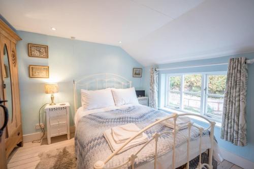 een slaapkamer met een bed en een raam bij Library Cottage, Marlesford in Woodbridge