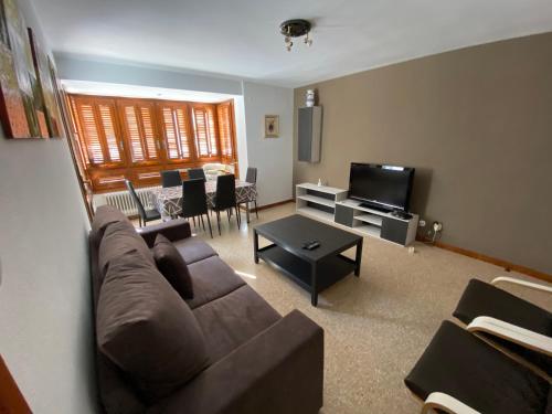 a living room with a couch and a tv at El Puente in Boltaña