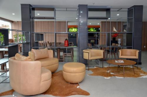a lobby with a couch and chairs and a table at M Tower Hotel in Pelotas