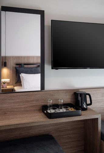a room with a tv and a table with glasses at Morum City Hotel Chania in Chania Town
