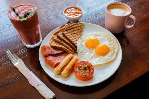 een bord ontbijtproducten met eieren, spek en toast bij Ascott Corniche Al Khobar in Al Khobar