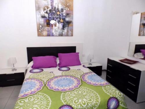 エル・メダノにあるEstrella del Marのベッドルーム1室(大型ベッド1台、紫色の枕付)