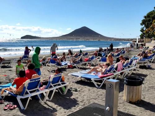 a group of people sitting in lawn chairs on a beach at Estrella del Mar in El Médano