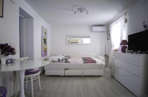 - une chambre blanche avec un lit et une table dans l'établissement Holiday Home Lavanda, à Raslina