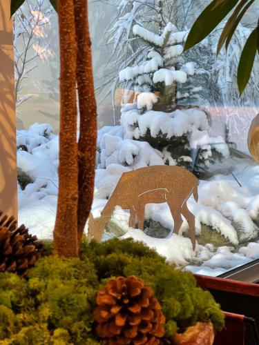 a christmas window display with a deer in the snow at Logis des Sittelles in Montfort-le-Gesnois