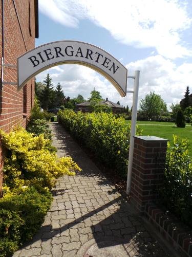 a sign for a berry garden next to a brick building at Hotel & Restaurant Hildebrandt in Breitenrode