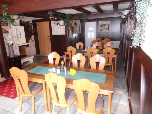 a dining room with a long table and chairs at Hotel & Restaurant Hildebrandt in Breitenrode