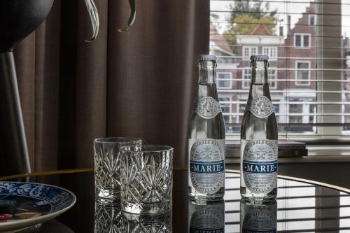 two bottles of wine sitting on a table with glasses at Boutique Hotel De Vier Patriciërs in Middelburg