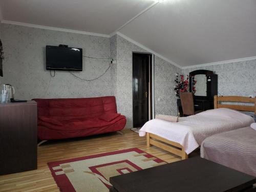 a living room with two beds and a red couch at Tamarindi Guest House in Mtskheta