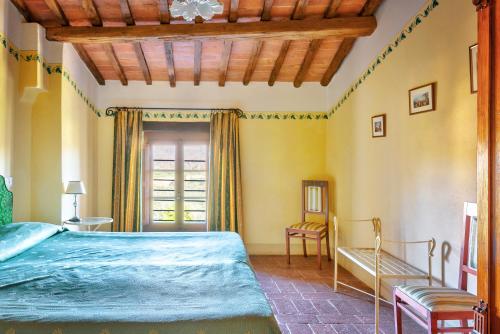 a bedroom with a blue bed and a window at Hotel Borgo Casabianca in Serre di Rapolano