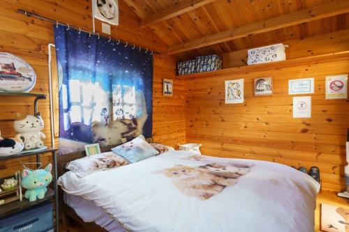 a bedroom with a bed in a wooden cabin at ヴィンテージ那須ハイランドパーク徒歩10分 一棟貸切 定員8名BBQ ファミリー向け 無料Wifi in Nasu