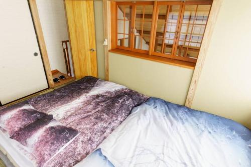 a bed in a room with a cabinet at ヴィンテージ那須ハイランドパーク徒歩10分 一棟貸切 定員8名BBQ ファミリー向け 無料Wifi in Nasu