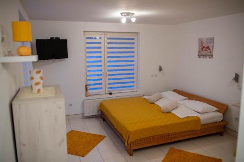 Un dormitorio con una cama amarilla y una ventana en Irinin Vidikovac en Rudnik Kačerski