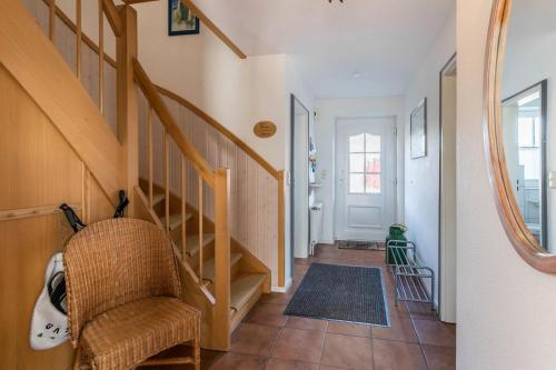 a hallway with a staircase and a chair in a house at Ferienhaus Kiebitz in Tönning