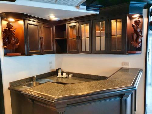 a kitchen with wooden cabinets and a sink at Sea Pearl Beach Resort in Patong Beach