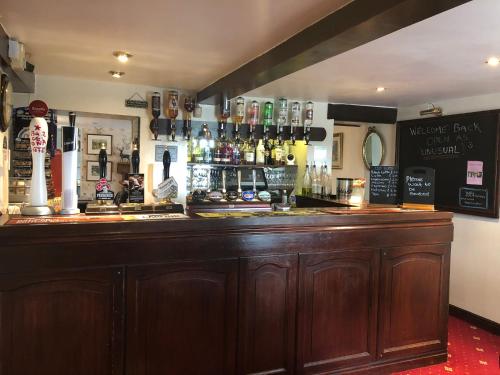 a bar in a pub with a large wooden counter at The Jug & Glass Inn in Hartington